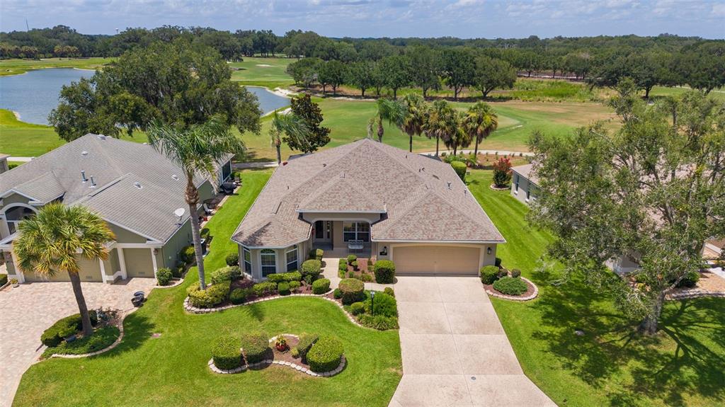 An aerial view of suburban houses bordering a golf course with a large pond — 1281 BETHUNE WAY, THE VILLAGES, FL