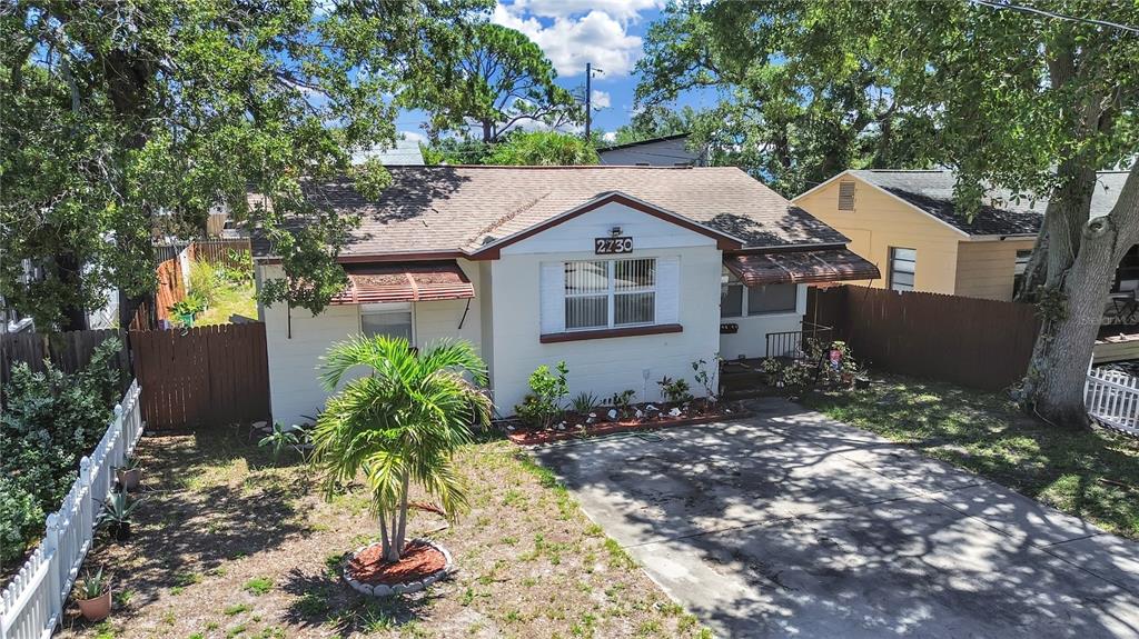 A single-story house with a concrete driveway, a palm tree, and a white picket fence — 2730 EDWARDS AVENUE S, ST PETERSBURG, FL