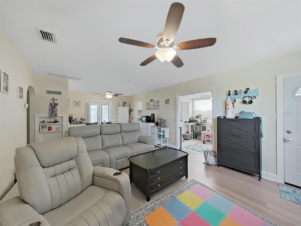 A living room features a gray sectional sofa, a black coffee table, and a ceiling fan — 2730 EDWARDS AVENUE S, ST PETERSBURG, FL