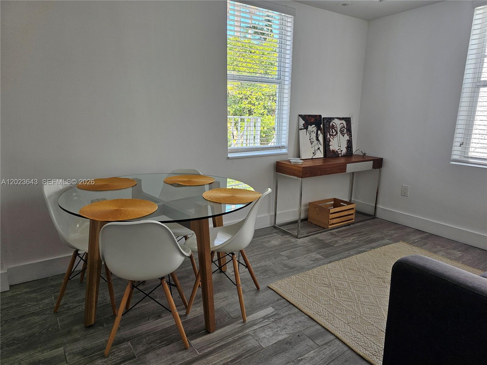 A dining area features a glass-topped table, white chairs, and a wooden console table — 622 15th St # 6, Miami Beach FL 33139, MIAMI BEACH, FL