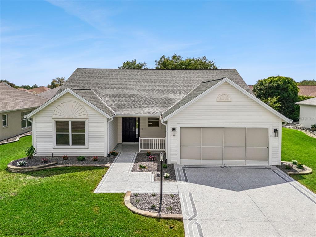 A single-story house with white siding, a gray shingled roof, and a concrete driveway — 1506 DELLANO WAY, THE VILLAGES, FL