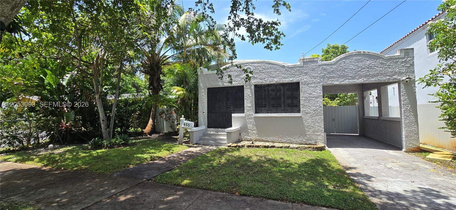 A single-story house with a textured white facade, a front porch, and a carport — 455 NE 131st St # 1, North Miami FL 33161, NORTH MIAMI, FL