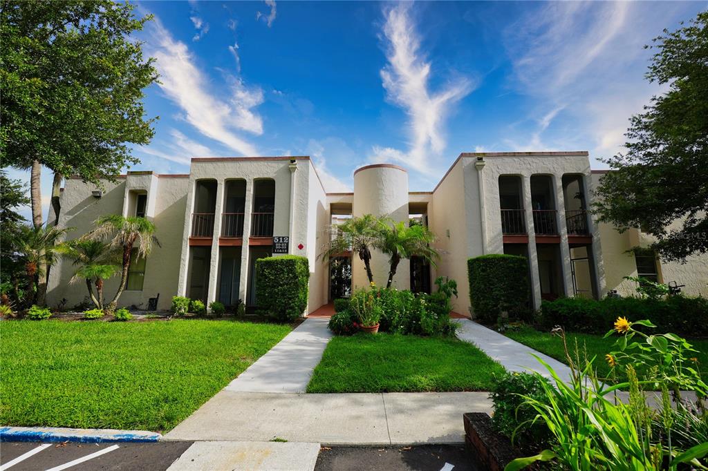 A two-story apartment building with a central courtyard, palm trees, and a grassy lawn — 512 ORANGE DRIVE UNIT 20, ALTAMONTE SPRINGS, FL