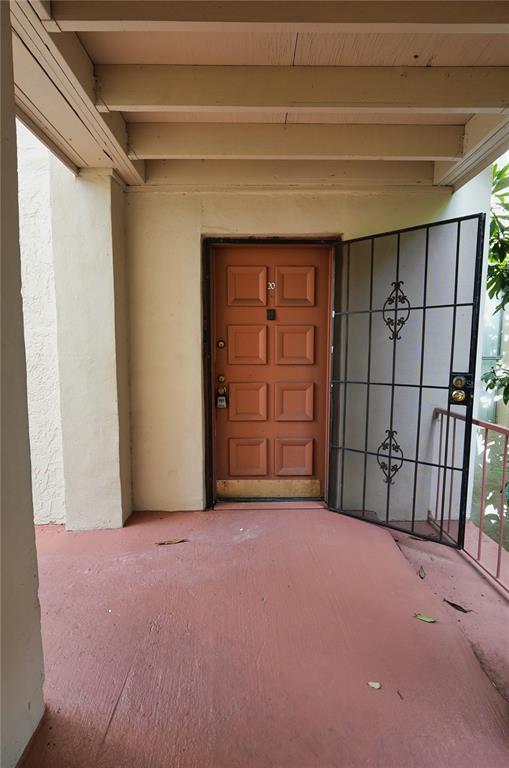 An exterior view of a building entrance with a brown door and a security gate — 512 ORANGE DRIVE UNIT 20, ALTAMONTE SPRINGS, FL