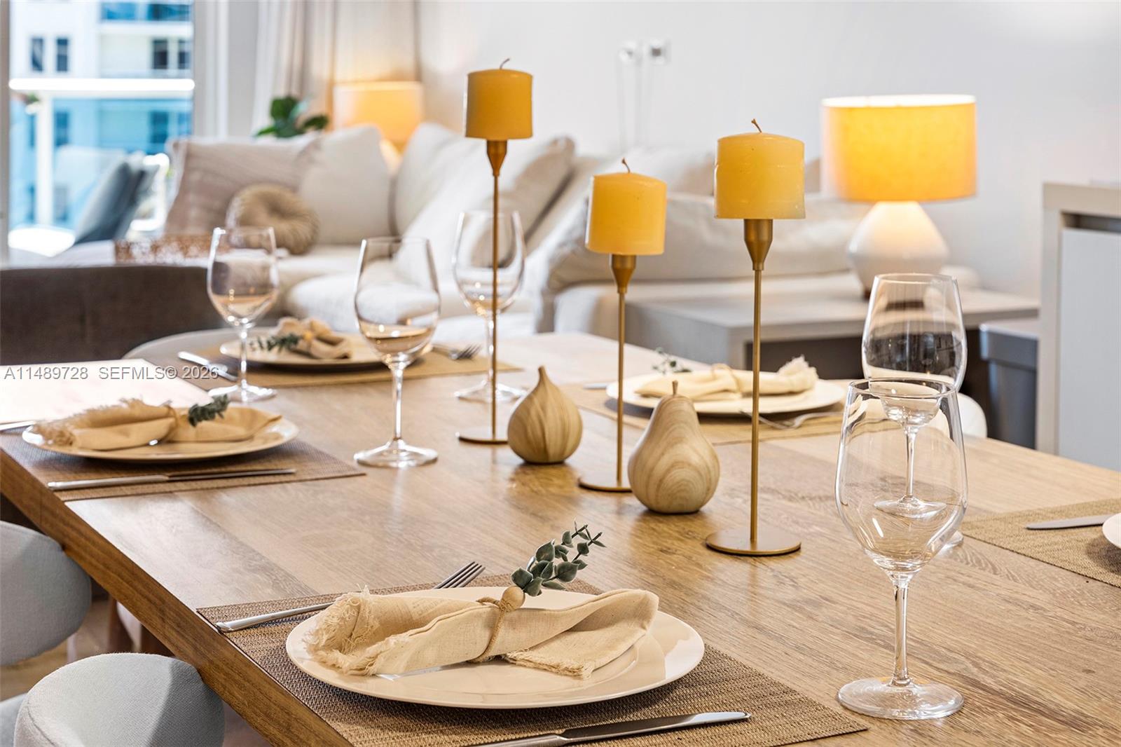 A dining table is set with candles, glassware, and napkins in a bright living space — 102 24th St # 1412, Miami Beach FL 33139, MIAMI BEACH, FL