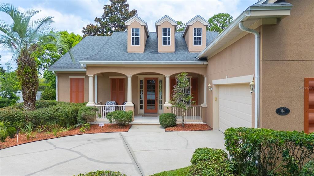 A tan house with a gray roof, three dormer windows, and a concrete driveway — 314 W LAKE VICTORIA CIRCLE, DELAND, FL