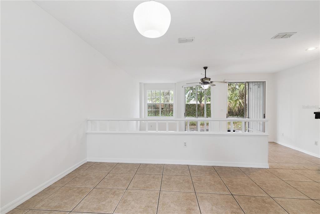 A tiled room features a half-wall with a white railing overlooking a lower living area — 685 SCARLET OAK CIRCLE UNIT 109, ALTAMONTE SPRINGS, FL