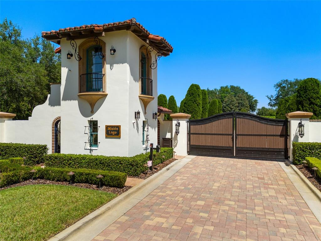 A gated entrance with a stucco tower and a brick driveway under a clear sky — 11865 FORT KING HIGHWAY, THONOTOSASSA, FL