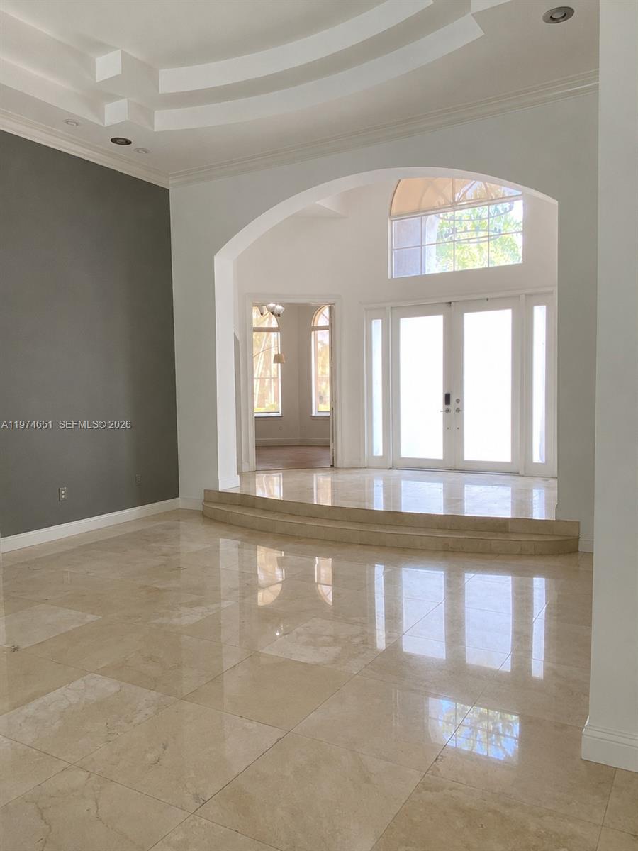 A foyer with a raised entryway, double glass doors, and polished tile flooring — 2503 Provence Cir, Weston FL 33327, WESTON, FL