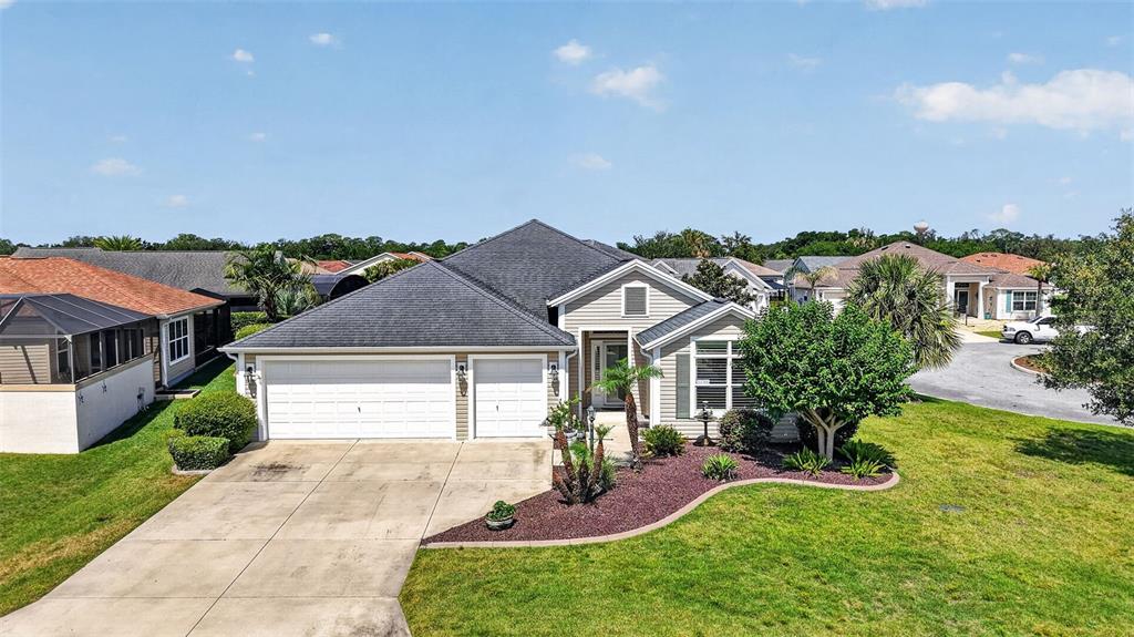 An exterior view of a single-story suburban house with a three-car garage and landscaping — 3746 NEW MOON AVENUE, THE VILLAGES, FL