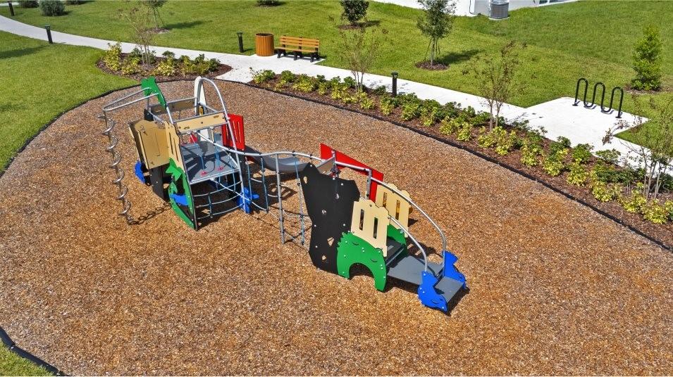 An aerial view shows a colorful playground structure situated on a wood-mulched surface — 2854 PIONEER TRAIL, EAGLE LAKE, FL