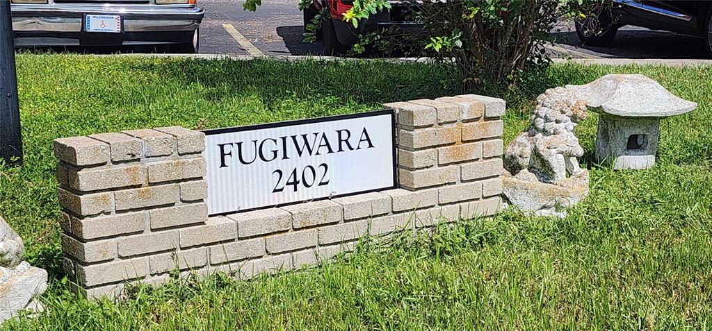 A brick sign displays the name Fugiwara and the number 2402 near a stone statue — 2402 ECUADORIAN WAY UNIT 22, CLEARWATER, FL