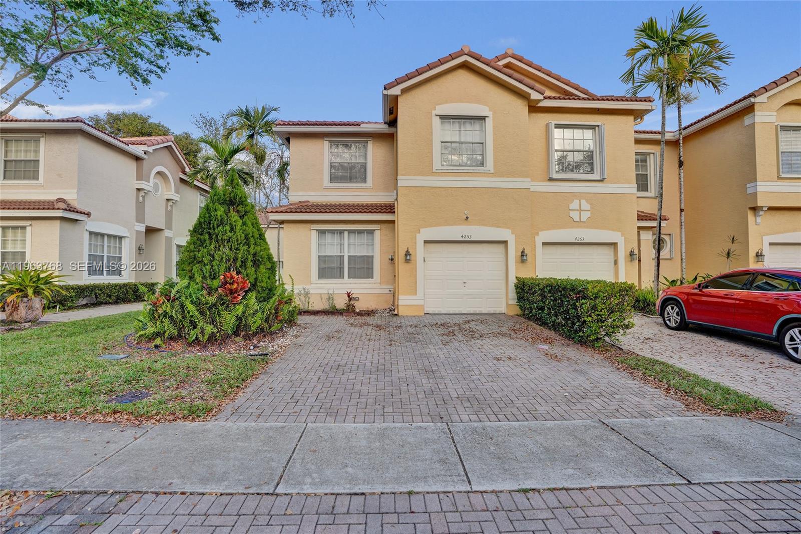 A patio features a modern sectional sofa, armchair, coffee table, and potted plants against a house — 4253 SW 124th Ter, Miramar FL 33027, MIRAMAR, FL