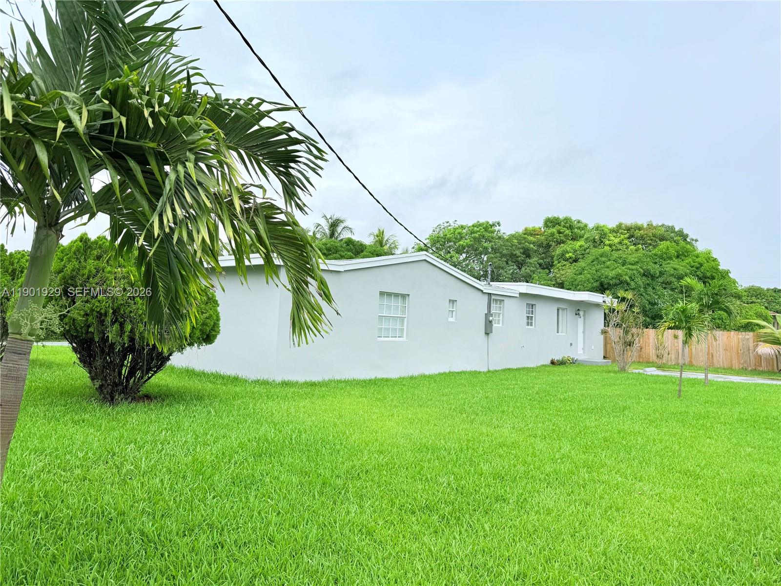 A gray house exterior features a large concrete driveway and a green lawn — 4340 SW 19th St, West Park FL 33023, WEST PARK, FL