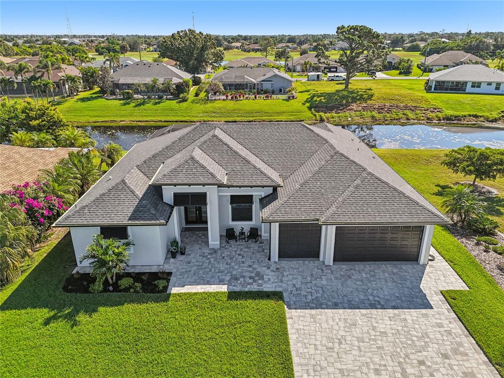An aerial view of a single-story house with a gray roof and paver driveway — 35 MEDALIST COURT, ROTONDA WEST, FL