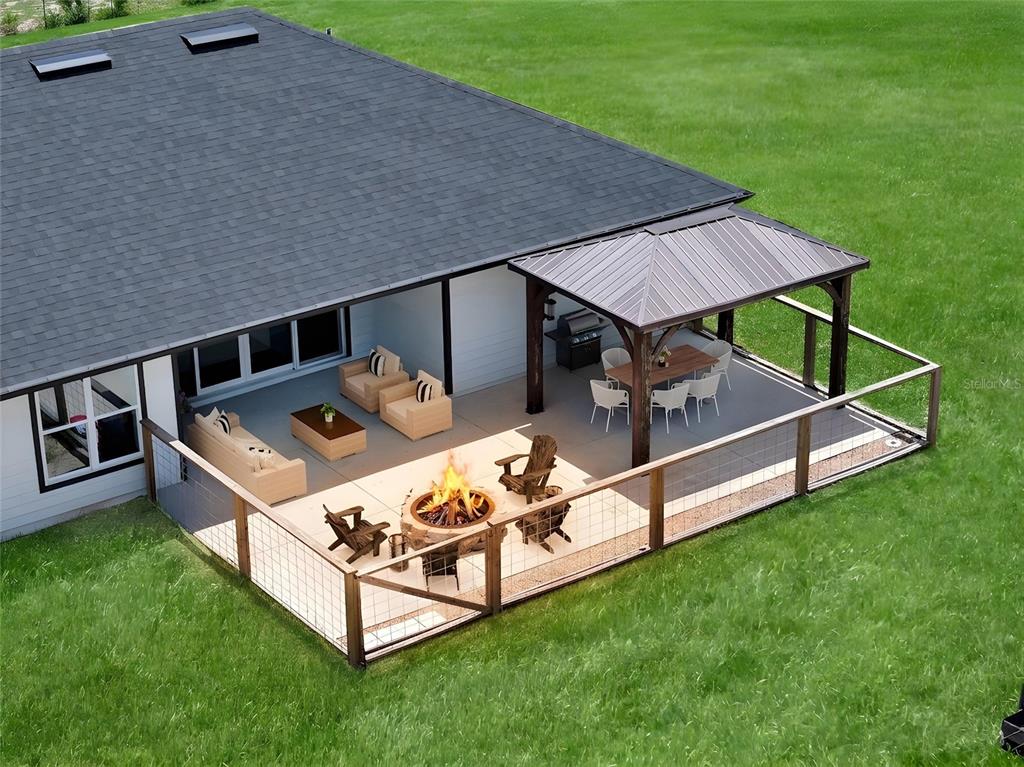 This is a digital rendering of a house exterior featuring a deck with a fire pit — 10240 NW 7TH TERRACE, BRANFORD, FL