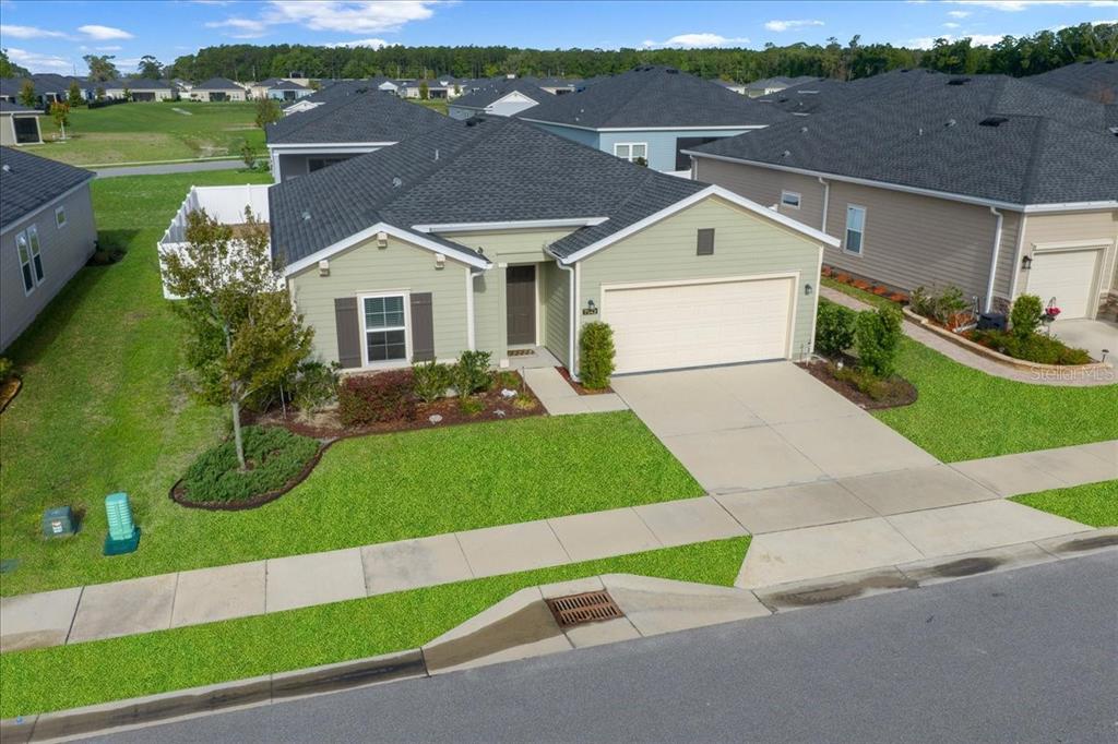 An aerial view of a single-story suburban house with a green exterior and two-car garage — 7542 SW 76TH TERRACE, OCALA, FL