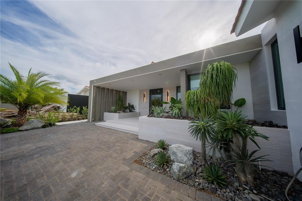 A modern home exterior features a covered entryway with stone steps and integrated landscaping planters — 1 CORREDOR MIRALAGO UNIT 908, DORADO, PR