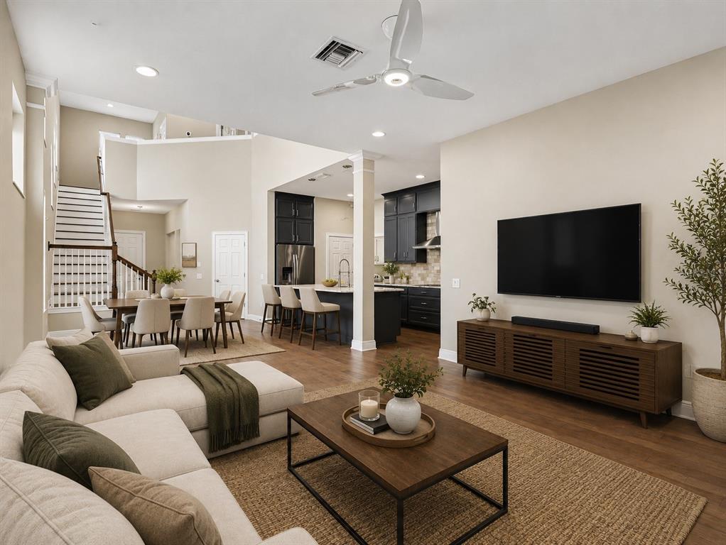 A living room with a sectional sofa, coffee table, and open kitchen with dark cabinets — 2424 WOOD STREET, SARASOTA, FL
