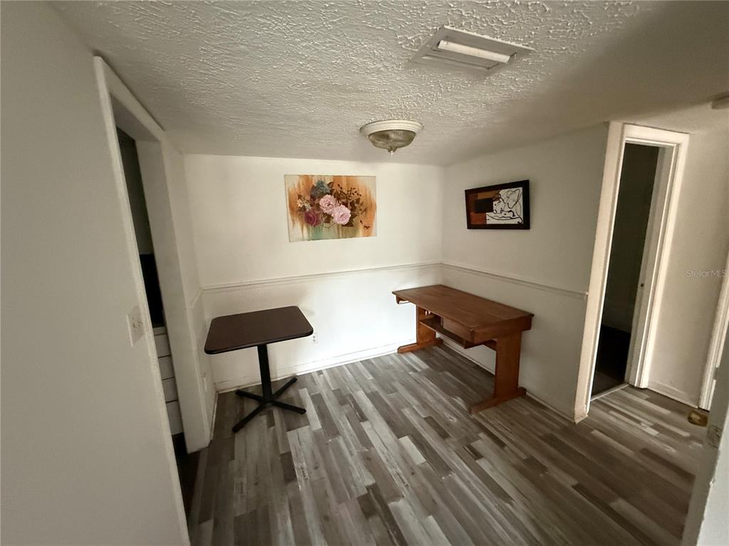 A room with wood-look flooring, white walls, a small table, and a wooden desk — 305 WYMORE ROAD UNIT 100, ALTAMONTE SPRINGS, FL
