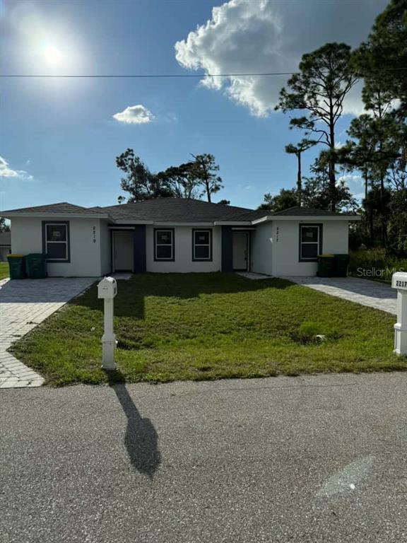 A single-story duplex with a central lawn, two paved driveways, and two separate entrances — 2217 FRASER STREET, PORT CHARLOTTE, FL