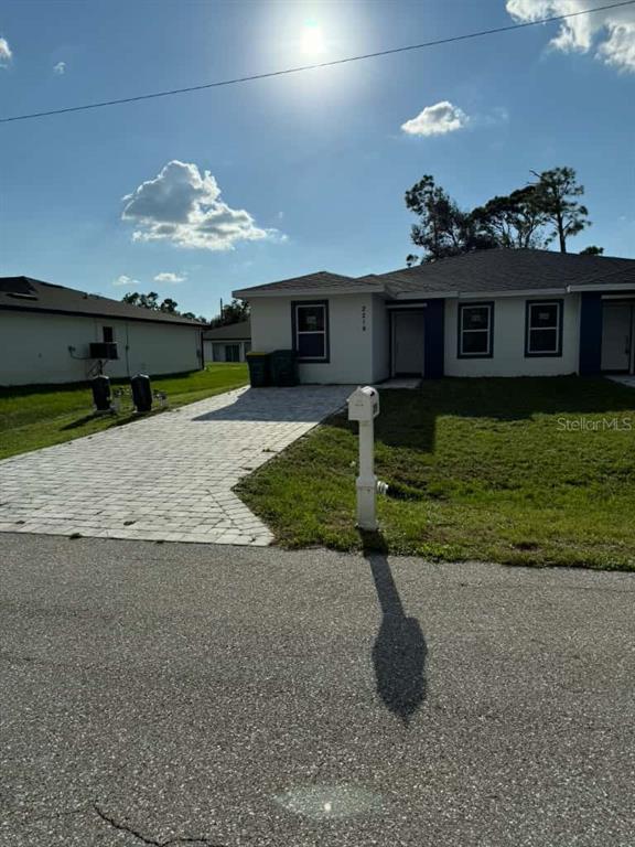 A single-story house with a paved driveway, white exterior, and a mailbox in the front yard — 2217 FRASER STREET, PORT CHARLOTTE, FL