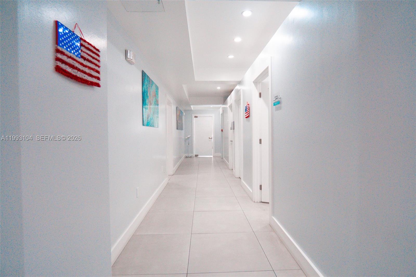 A long, white-walled hallway features light-colored tile flooring and recessed ceiling lighting — 2268 SW 8th St, Miami FL 33135, MIAMI, FL