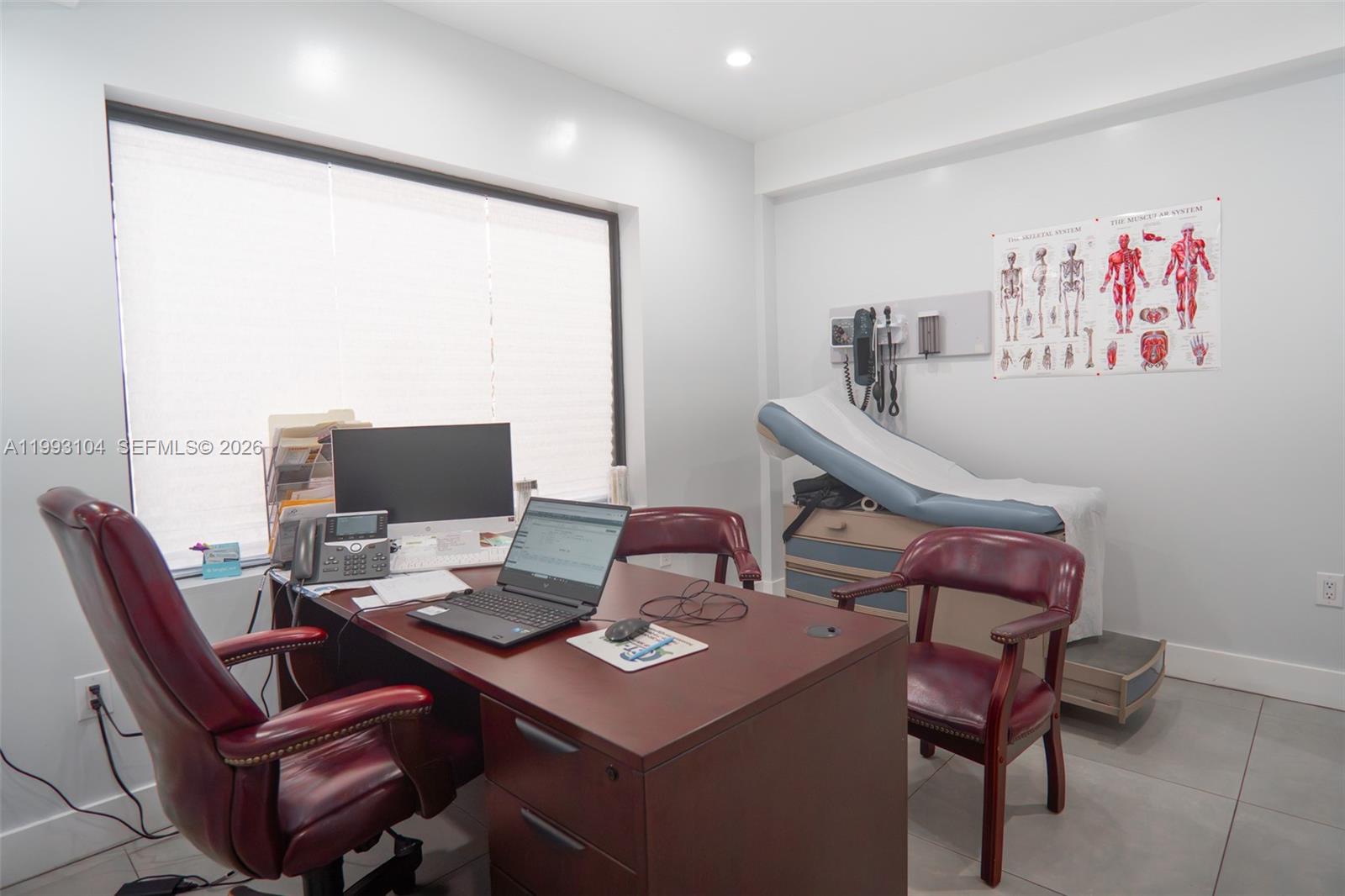 A medical office features a desk, chairs, an examination table, and anatomical wall charts — 2268 SW 8th St, Miami FL 33135, MIAMI, FL