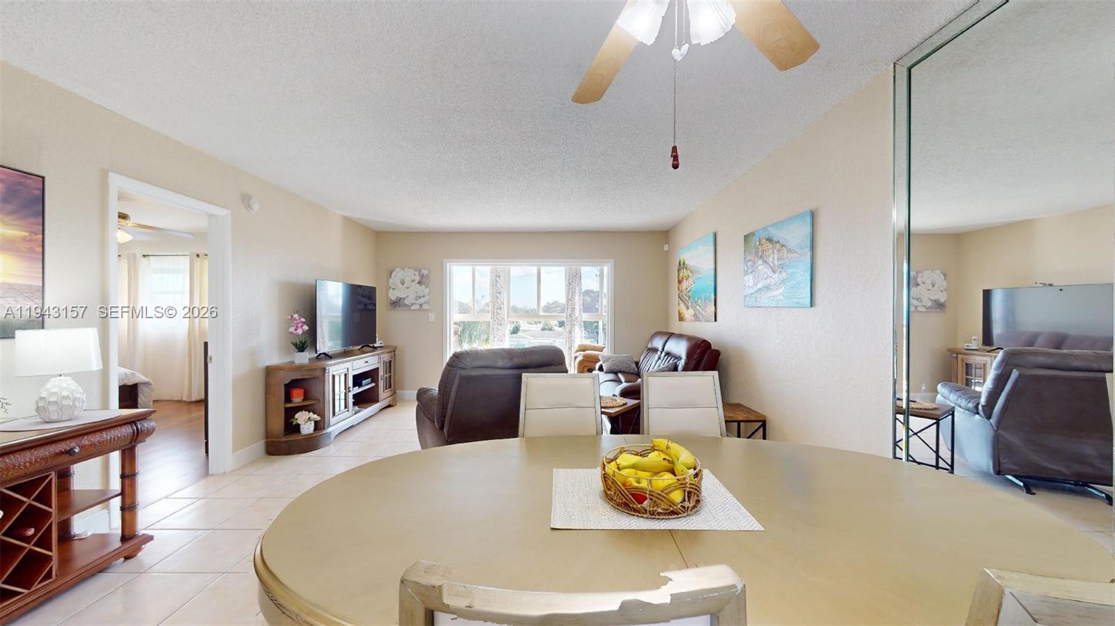 A dining area with a round table opens into a living room with leather furniture — 7877 Golf Cir Dr # 304, Margate FL 33063, MARGATE, FL