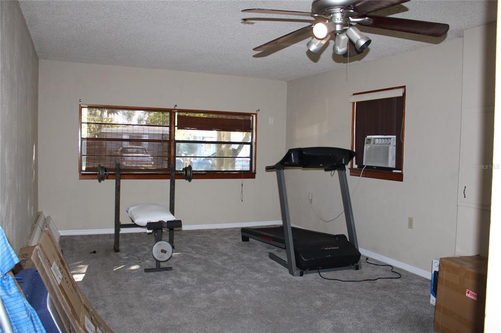 A room with gray carpet, a ceiling fan, a treadmill, and a weight bench — 6121 56TH AVENUE N, ST PETERSBURG, FL