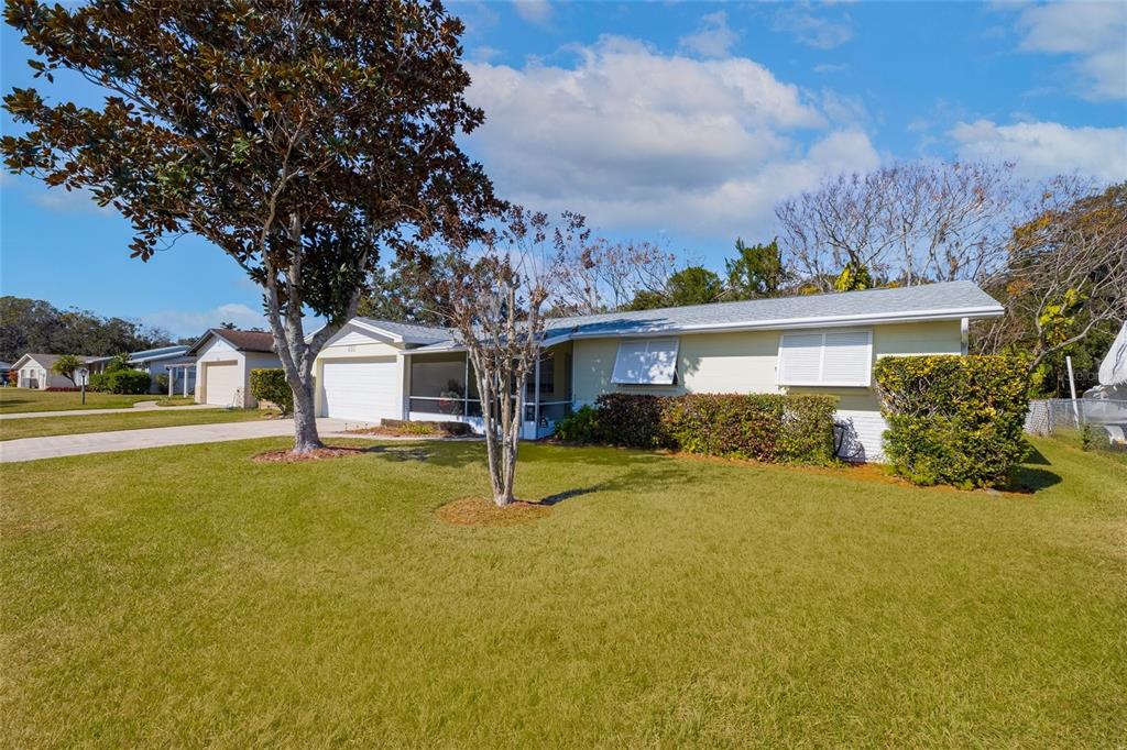A single-story house with a light yellow exterior, a garage, and a large front lawn — 692 GASLIGHT DRIVE, SOUTH DAYTONA, FL