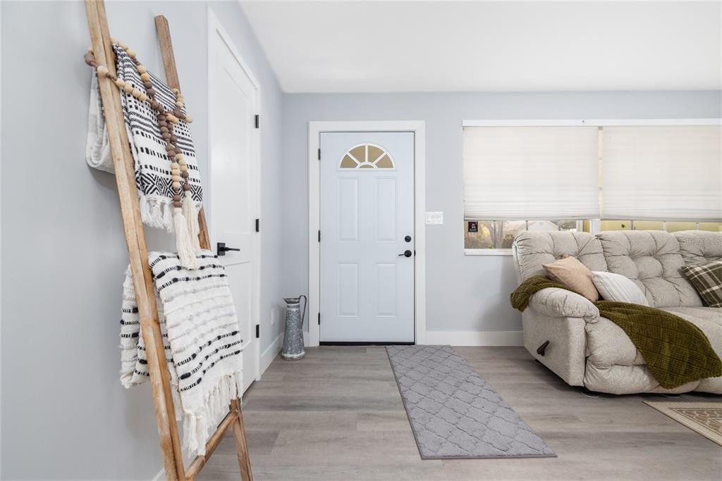 A living room entrance features a wooden blanket ladder, a white door, and gray flooring — 692 GASLIGHT DRIVE, SOUTH DAYTONA, FL