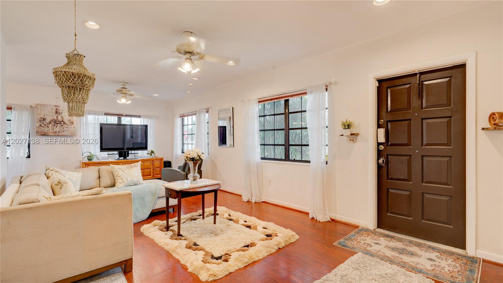 A living room features hardwood floors, a beige sofa, a coffee table, and a door — 10420 SW 149th St, Miami FL 33176, MIAMI, FL