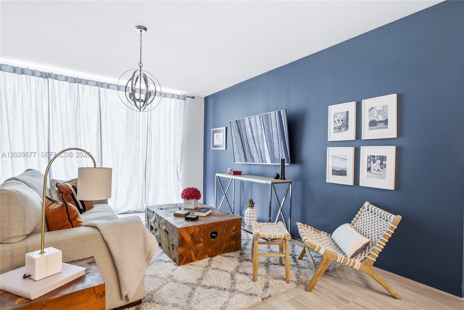 A living room features a blue accent wall, a wooden coffee table, and a sofa — 31 SE 5th St # 2410, Miami FL 33131, MIAMI, FL