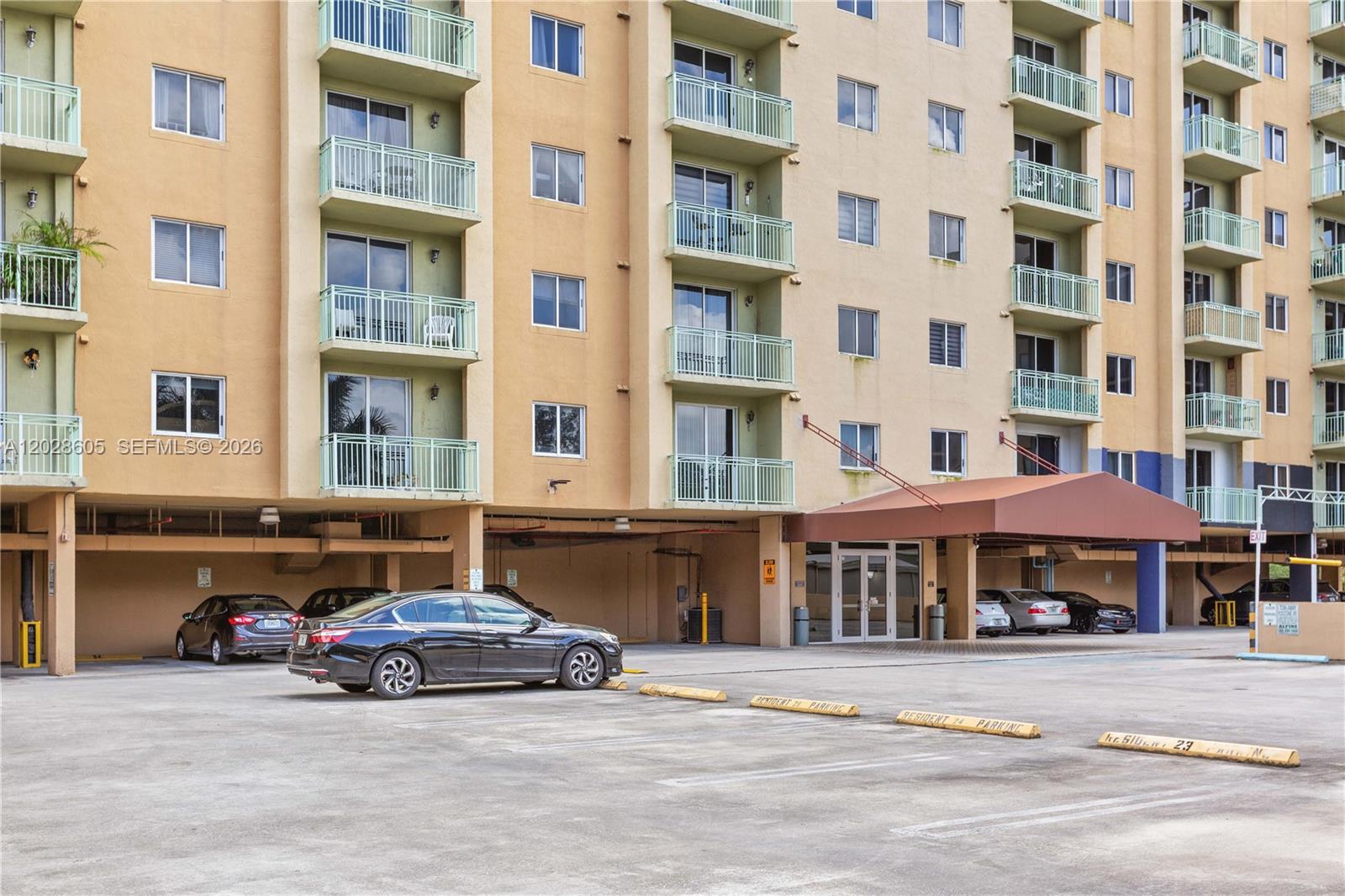 A multi-story apartment building features balconies and a covered entrance above a parking lot — 3500 Coral Way # 614, Miami FL 33145, MIAMI, FL