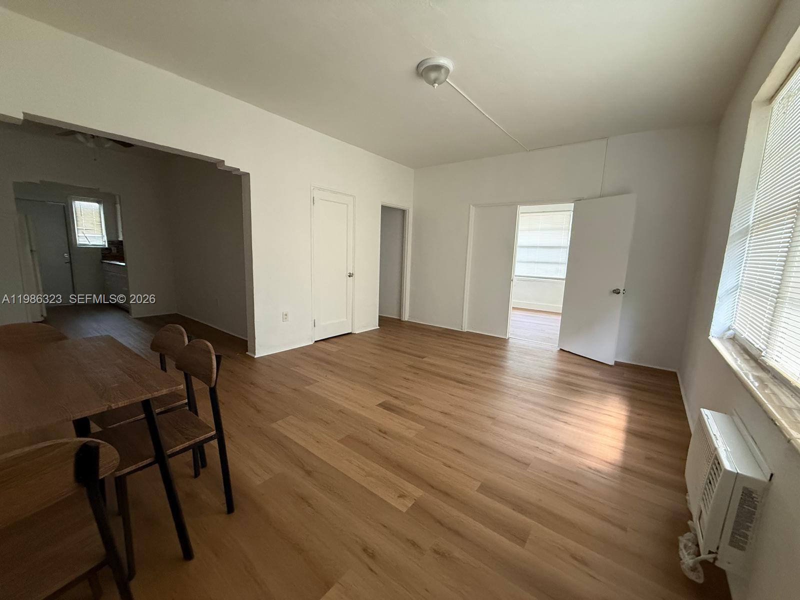 An unfurnished room with light wood-look flooring, white walls, and an open doorway — 6830 Harding Ave # 1, Miami Beach FL 33141, MIAMI BEACH, FL