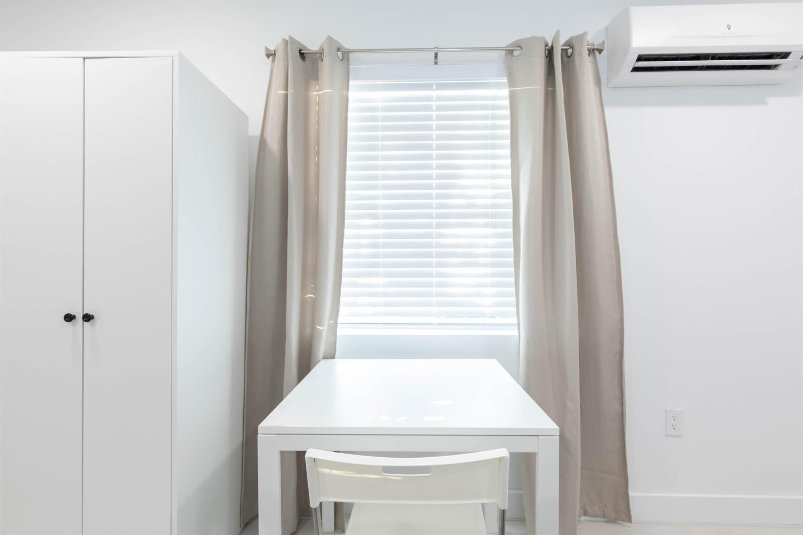 A white table and chair sit in front of a window with beige curtains — 1826 Jefferson Street, Hollywood FL 33020, HOLLYWOOD, FL