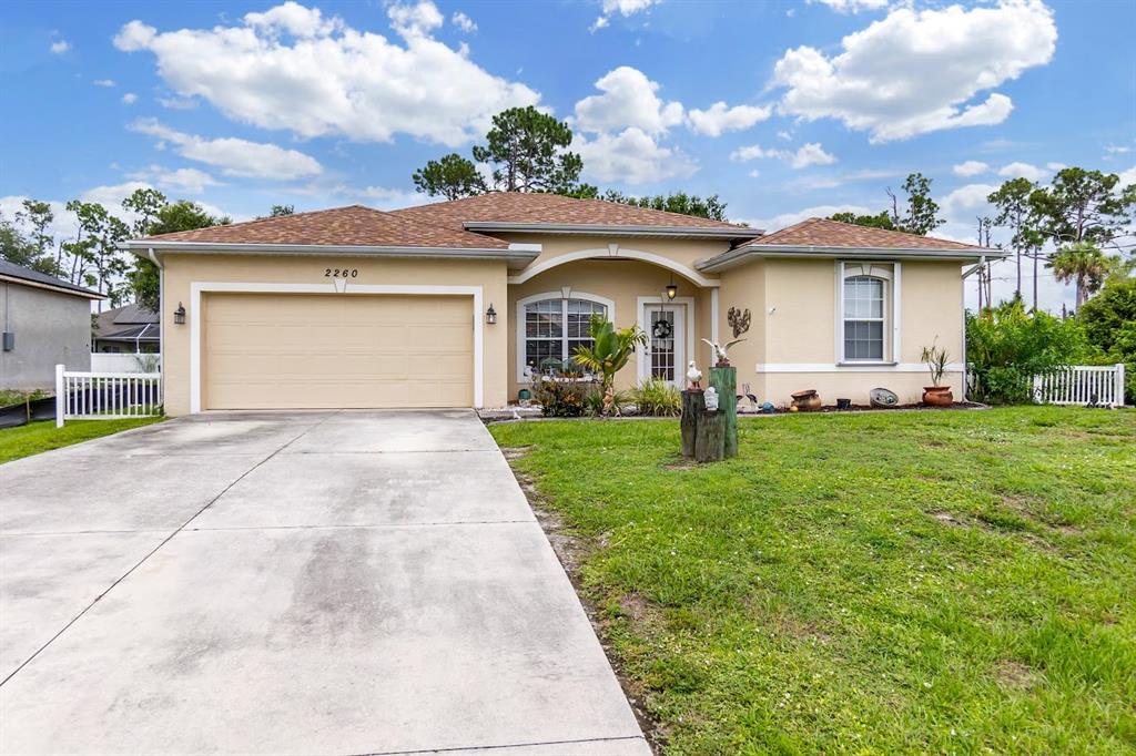 A single-story house with a beige stucco exterior, a two-car garage, and a concrete driveway — 2260 ZUYDER TERRACE, NORTH PORT, FL