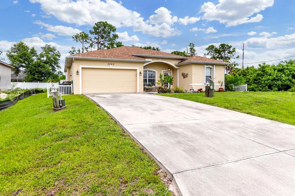 A single-story house with a tan exterior, a two-car garage, and a concrete driveway — 2260 ZUYDER TERRACE, NORTH PORT, FL