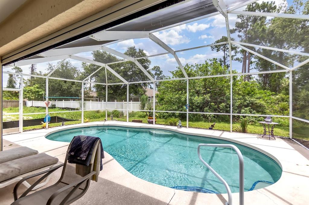 A screened-in patio features a swimming pool and a view of the backyard — 2260 ZUYDER TERRACE, NORTH PORT, FL