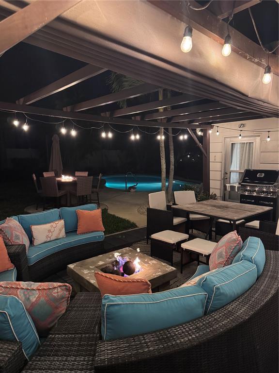 A covered outdoor patio features a curved sectional sofa, fire pit, dining area, and pool — 6304 BEECHWOOD AVENUE, SARASOTA, FL