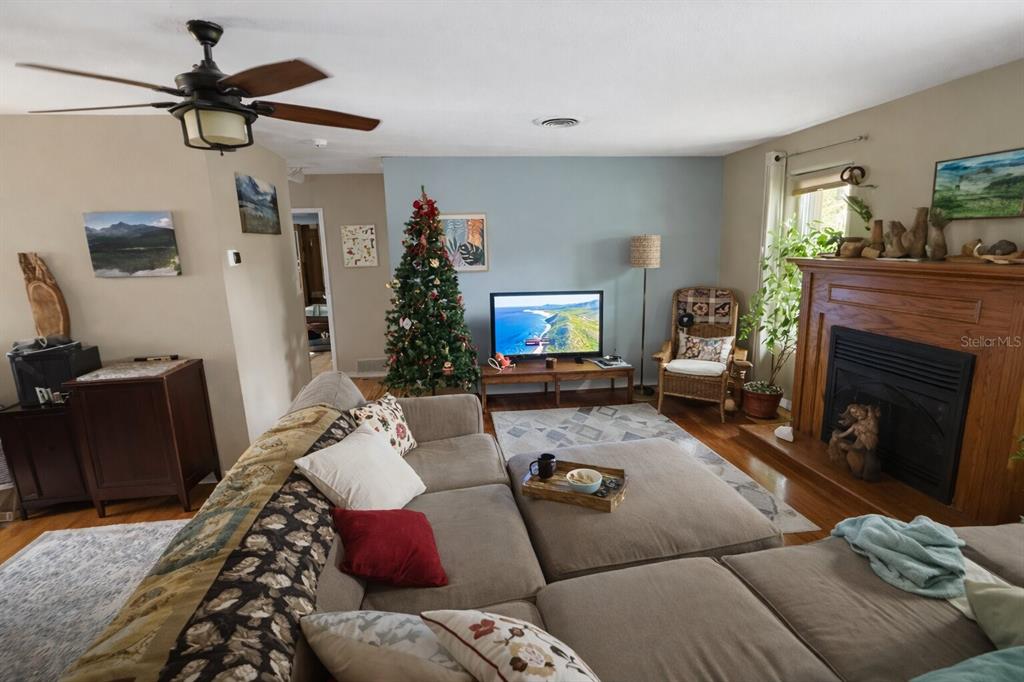 A living room features a sectional sofa, a fireplace, a television, and a Christmas tree — 321 ROSLYN AVENUE, NEW SMYRNA BEACH, FL