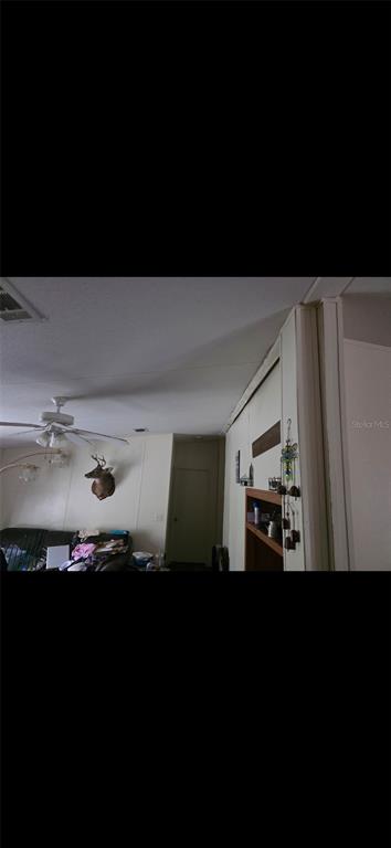 A living room features a ceiling fan, a deer head mount, and wood-paneled walls — 210 SANTA ROSA ROAD, CANTONMENT, FL