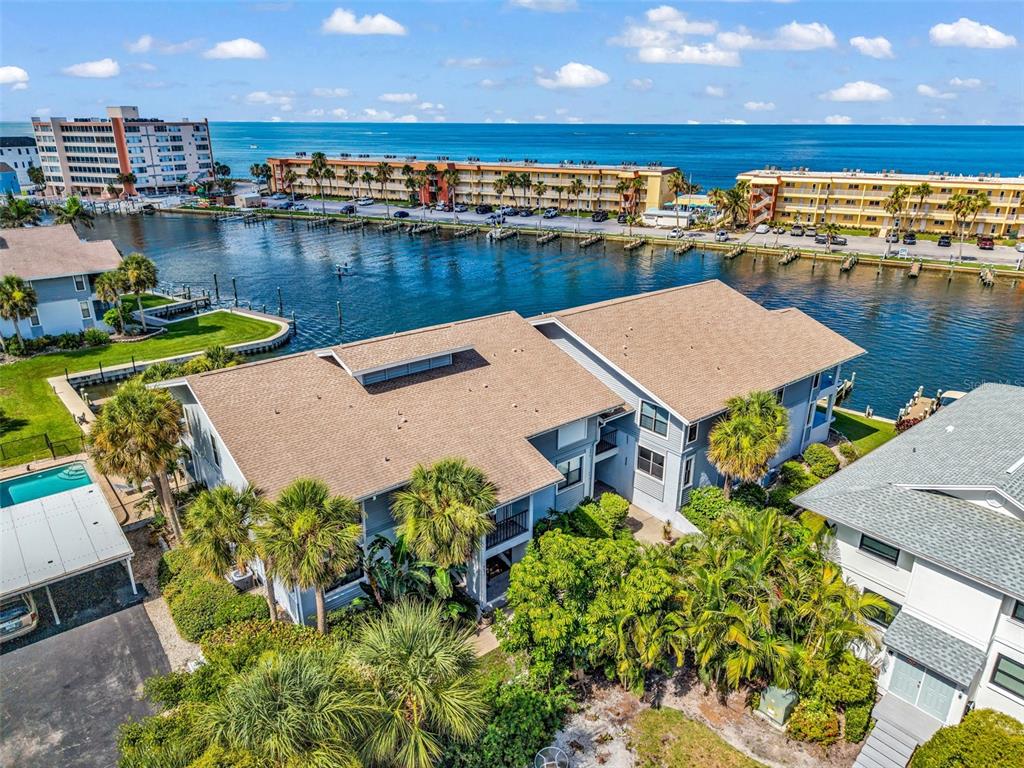An aerial view shows a multi-story apartment building with a brown roof near a canal — 9050 MIDNIGHT PASS ROAD UNIT 1, SARASOTA, FL