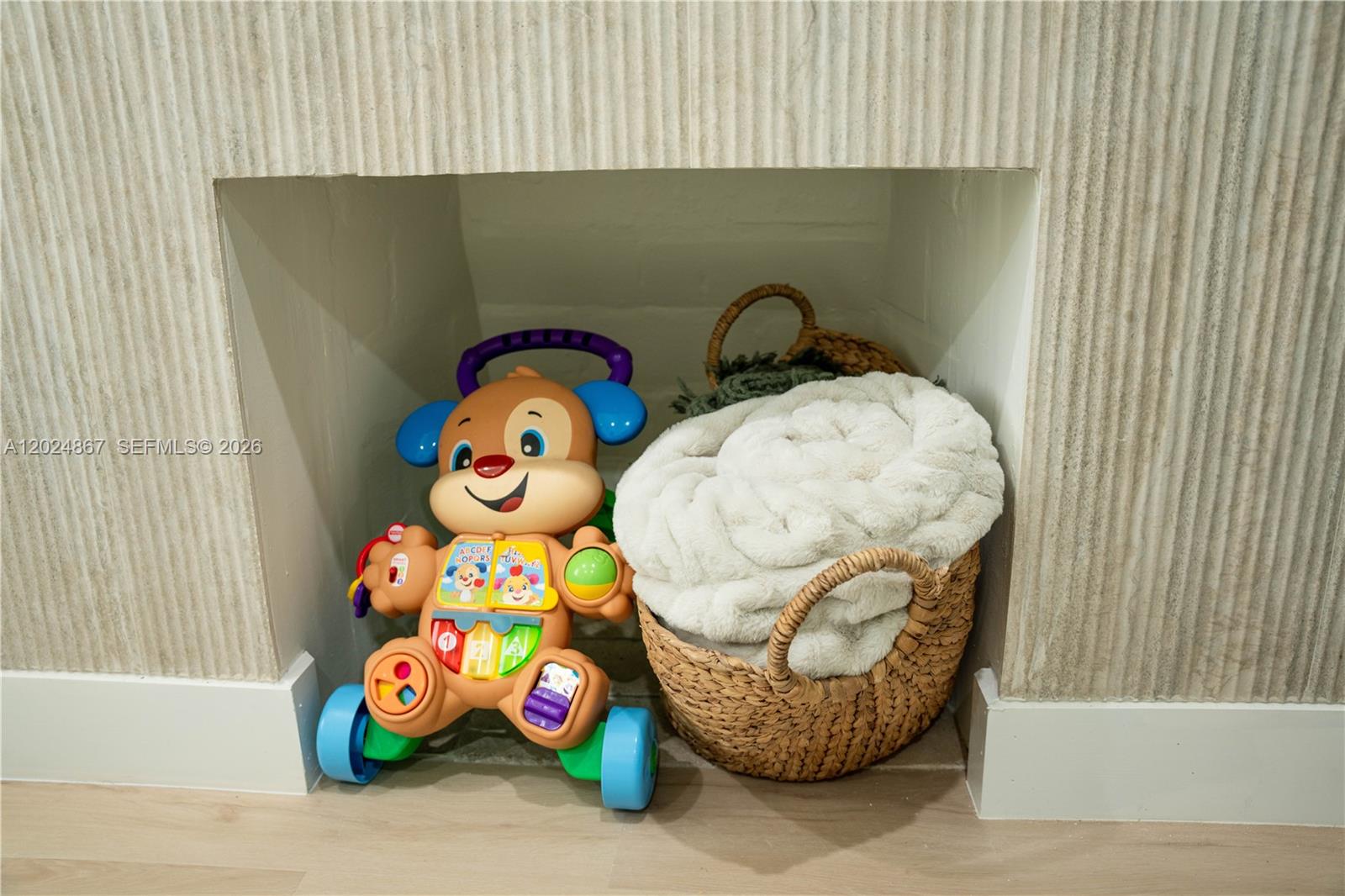 A toy walker and a basket with a blanket sit inside a fireplace alcove — 247 NW 58th St, Miami FL 33127, MIAMI, FL