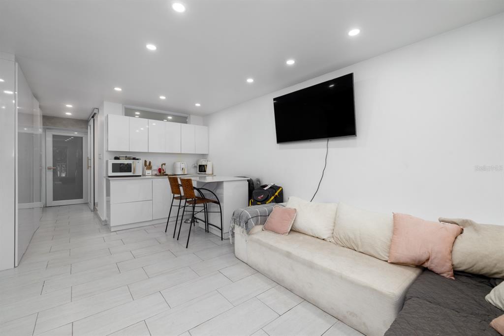 A bright living room features white tile floors, a sectional sofa, and a balcony view — 4633 AV. ISLA VERDE UNIT 105, CAROLINA, PR