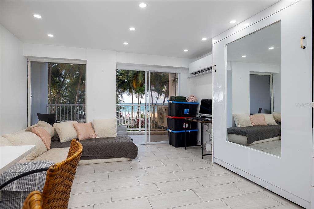 A white Murphy bed with a mirror faces a kitchen with white cabinetry and island — 4633 AV. ISLA VERDE UNIT 105, CAROLINA, PR