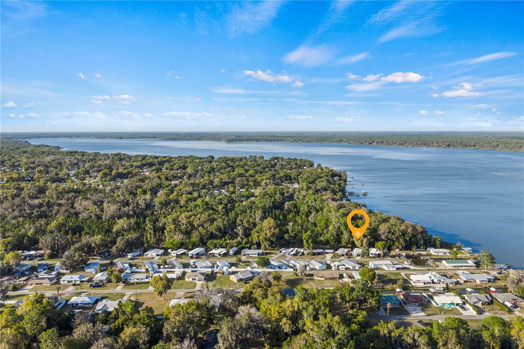 An aerial view shows a residential neighborhood situated along the shore of a large lake — 942 CR 461, LAKE PANASOFFKEE, FL