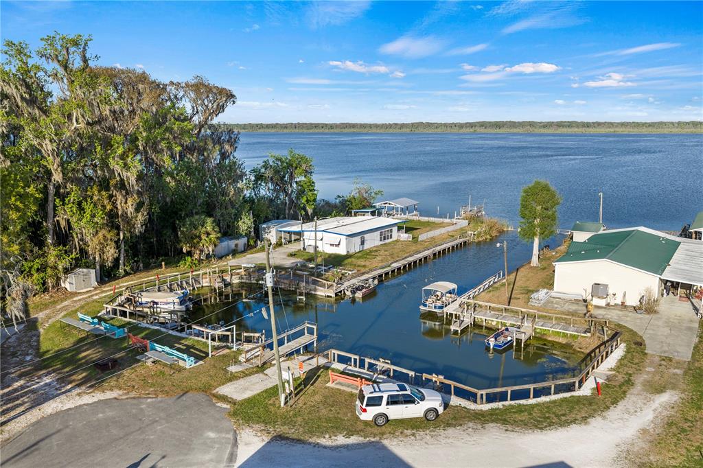 An aerial view shows a waterfront property with a private boat basin and two buildings — 942 CR 461, LAKE PANASOFFKEE, FL