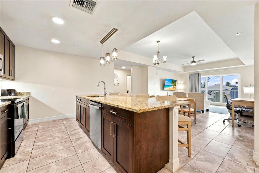An aerial view of a hotel building featuring a rooftop swimming pool and lounge area — 24 AVALON STREET UNIT 405, CLEARWATER BEACH, FL